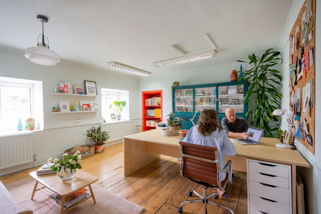 Alice and Stephen of Boaz Studio discussing a project at their desk in their Truro, Cornwall office.