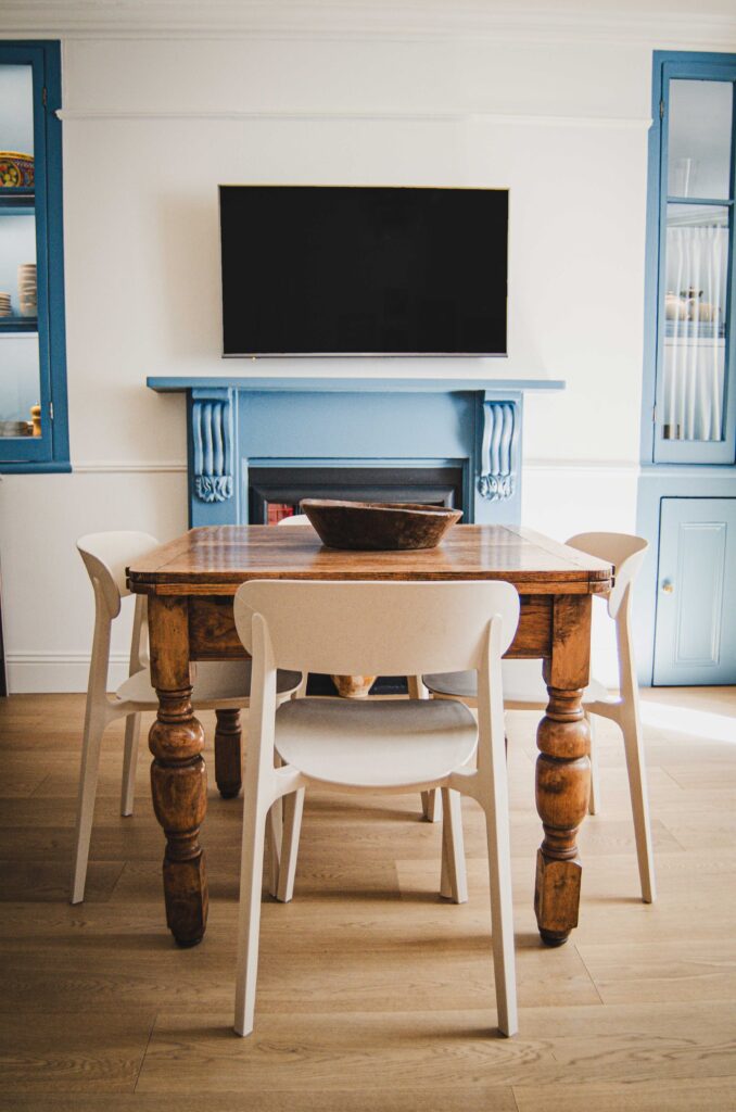 Vintage table and eco chairs in front of blue fireplace