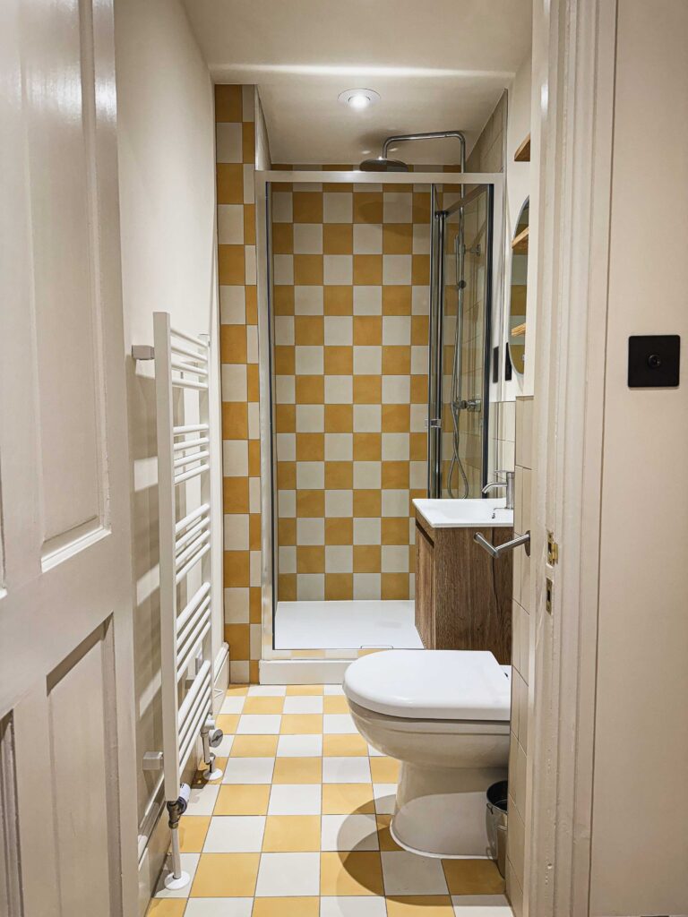 Yellow and white checkerboard tiles in small bathroom
