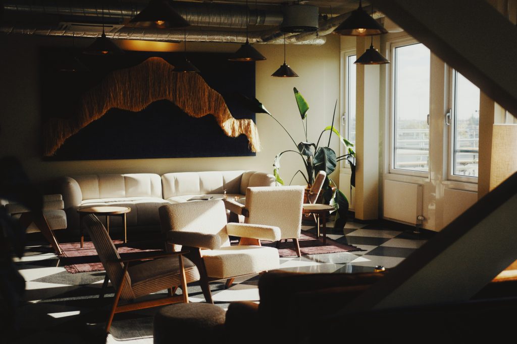 Soft seating and plant in corner of room with windows